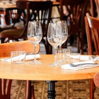 Une table de restaurant avec verres à vin et couverts préparés, avec tons vifs Une table de restaurant avec verres à vin et couverts préparés, avec tons vifs