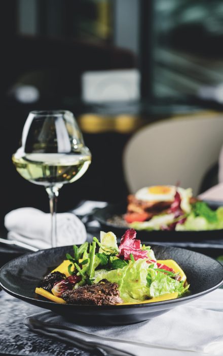 Delicious meat dish with salad leaves on the table in the restaurant
